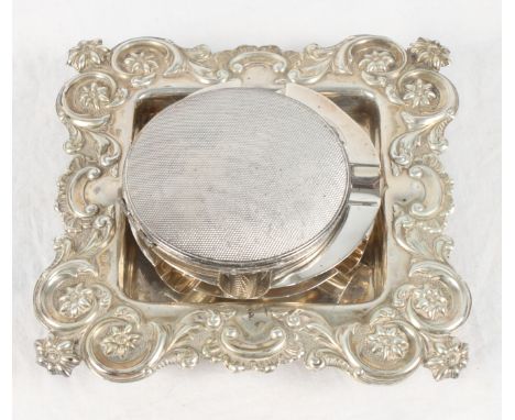 A square silver butter dish stand with repoussé floral and scroll decorated border, a pair of circular silver ashtrays and an