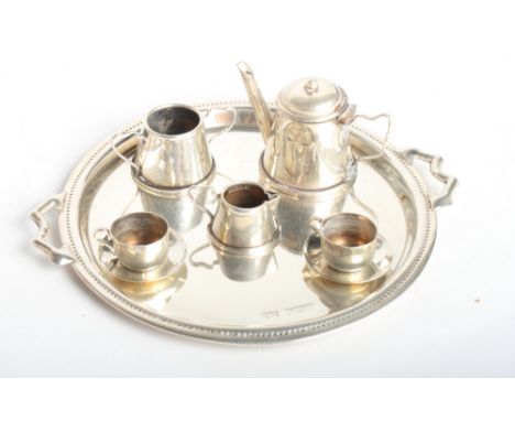 A doll's silver morning tea set with circular tray, 3 1/2" dia, 1.36oz troy approx, and an early 19th Century Dublin silver "