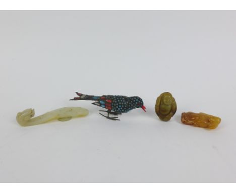 Three carved jade items to include a belt hook, a Buddha and a boy together with a small brass bird embellished with turquois