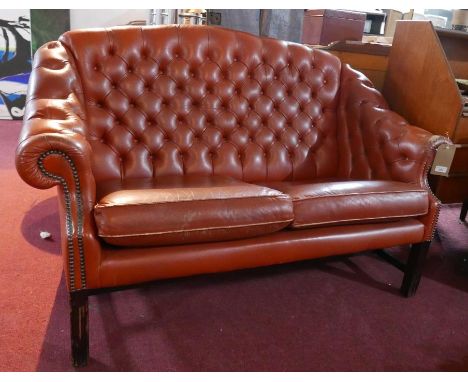A 'Pegasus' Chesterfield style sofa with tan leather button back upholstery, raised on reeded mahogany legs joined by stretch