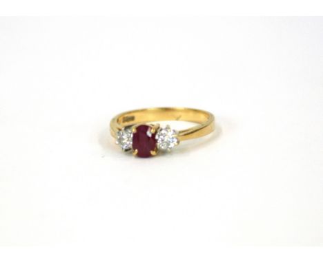 A gold ring set central ruby, flanked by diamonds