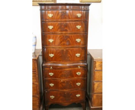 A reproduction mahogany serpentine shaped chest on chest, of small proportions, fitted seven drawers and a brushing slide, ra