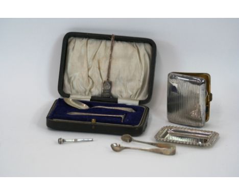 A cased silver Christening spoon and pusher, Birmingham 1922; a pair of silver sugar tongs; an engine turned silver cigarette