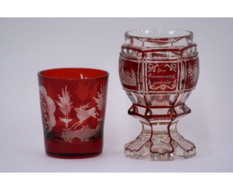 A Bohemian ruby flash pedestal goblet, with decorated panels, 13cm high; and a ruby beaker decorated with stags, foliage and 