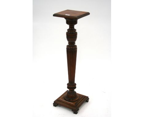 A late Victorian mahogany jardiniere stand, having square top raised on a turned fluted baluster column and stepped base, ter