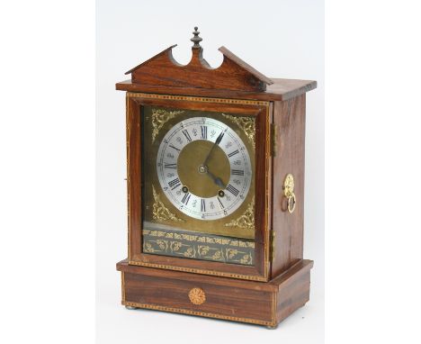 A walnut and inlaid cased mantel clock, the eight day movement striking on a gong, 47cm high x 28.5cm wide