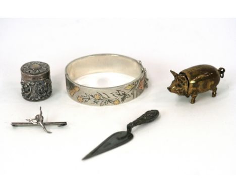 A silver thimble contained in an Edwardian silver embossed case; a white metal and yellow metal inlaid snap bangle; a white m