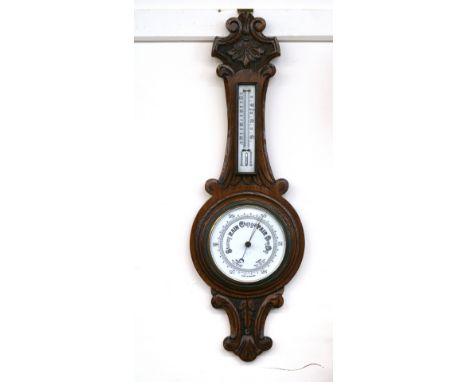 An Edwardian carved oak banjo barometer thermometer