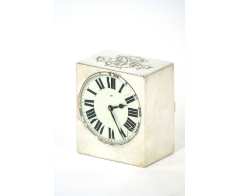 A small Swiss white metal cased clock, with foliate scroll decoration, circular enamel Roman numeral dial, retailed by Tiffan