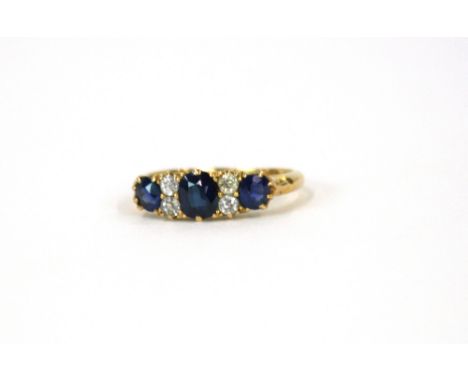 An 18ct gold ring, set three sapphires and four diamonds 