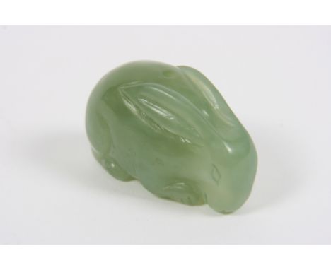 A 19th Century Chinese carving in translucent green jade of a rabbit, drilled as a toggle, 5cm long 