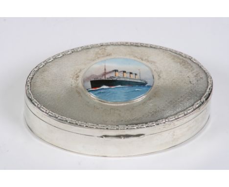 An oval silver trinket box, the hinged lid inset with enamel panel of a four funnel steam ship with engine turned decoration,