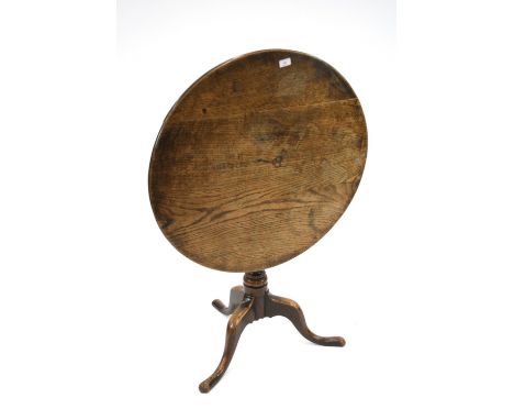 An 18th Century oak tea table, the circular snap top raised on a turned baluster column and tripod base, 78cm dia.