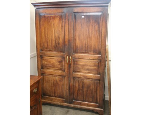 A Georgian mahogany hanging wardrobe, enclosed by a pair of triple fielded panelled doors, raised on bracket feet, 130cm wide