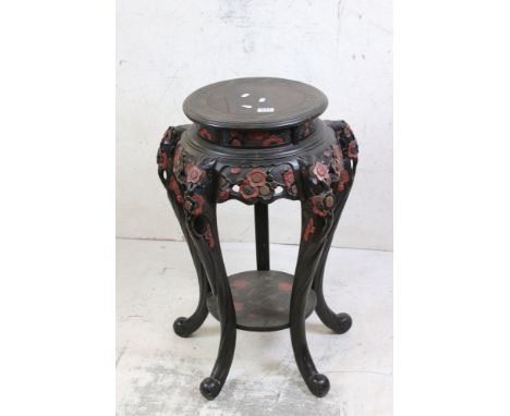 Chinese Ebonised and Red Lacquered Hardwood Stand, carved with flowers and foliage, raised on five curving legs united by an 