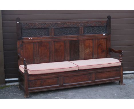 18th century Oak Hall Settle Bench, the triple back with carved upper panels and top rail, carved arms, box seat with double 
