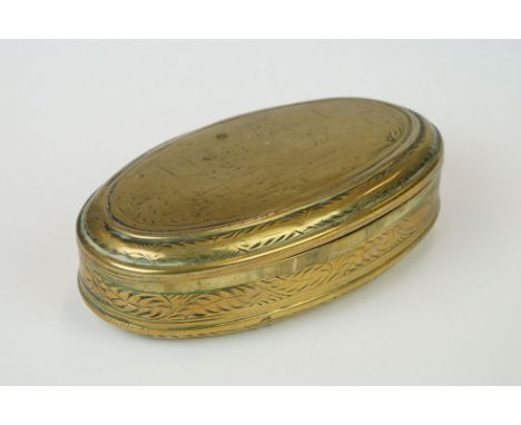 An antique 18th century oval brass snuff box with ornate chased decoration. 