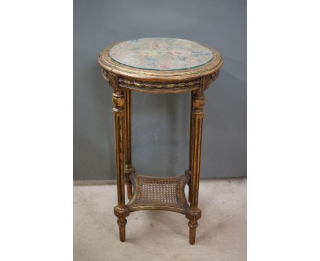 French style Giltwood Circular Lamp Table, the needlework panel top top with glass cover, the four turned reeded legs united 