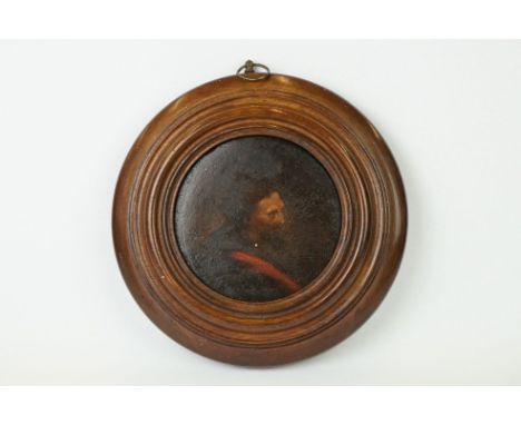 A miniature portrait of a gentleman in traditional dress within a circular frame. 