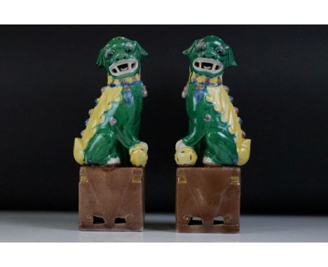 Pair of 20th Century Chinese ceramic Dogs of Foo figures in green and yellow glaze, raised on square-shaped bases, approx 25c