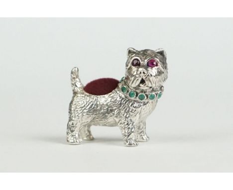 Silver pincushion in the form of a dog with ruby eyes and emerald collar 