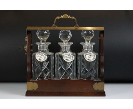 Early 20th Century mahogany &amp; brass three bottle tantalus with brass mounts &amp; carry handle, three matching Royal Brie