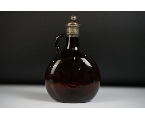 19th Century amber glass spirit flask with white metal mount &amp; stopper, the glass body of bulbous form, with a looped han