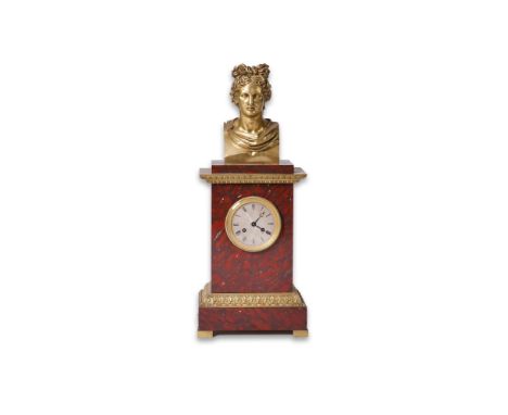 A mid 19th century French ormolu mounted rouge marble mantel clock surmounted with the bust of Apollo, with silvered Roman di