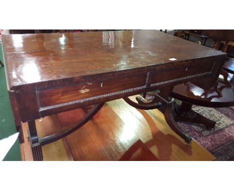 An Early 19th Century Mahogany Sofa Table; the beaded frieze fitted with a drawer and a false drawer to either side, on reede