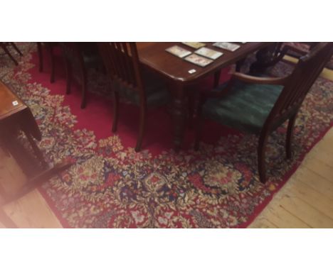 A Persian Red Ground Carpet; the central medallion and scrolling floral detail within running borders.