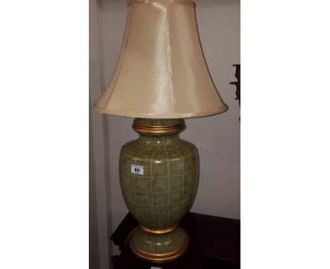 A Good Quality Green and Gold Patterned Ceramic Table Lamp; with yellow silk shade.