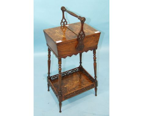 A Victorian walnut sewing box of tapered rectangular shape with two hinged inlaid flaps and carrying handle on splayed turned