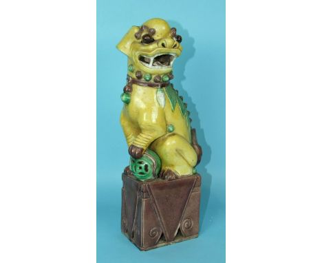 A large 19th century Chinese famille verte model of a seated lion dog and pierced ball on a tall plinth, 39cm high.
