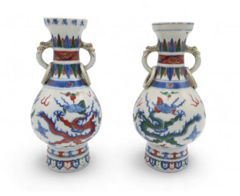 A PAIR OF CHINESE DOUCAI VASES Painted with dragons and phoenix, beneath fixed ring handles, six character reign marks to rim