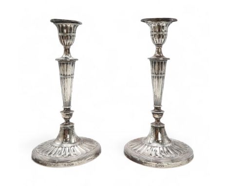 A PAIR OF GEORGE V SILVER CANDLESTICKS by William Hutton &amp; Sons, Sheffield 1921, in the neo-classical style, with a taper