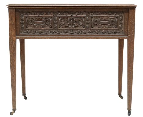 A 19TH CENTURY OAK SIDE TABLEWith rectangular hinged top over carved friezes on square tapering supports terminating in ceram