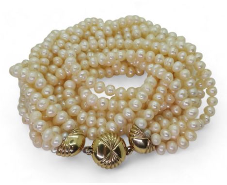 MULTI STRAND PEARLS with a fancy fan patterned yellow and white 9ct gold box clasp, the cream freshwater pearls are slightly 