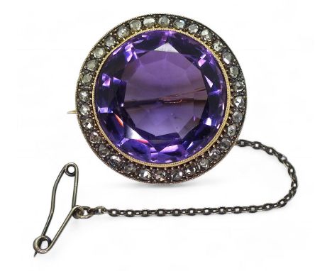 A SUBSTANTIAL AMETHYST BROOCH set with a round cut amethyst of 20mm x 12mm, surrounded with a ring of rose cut diamonds to th