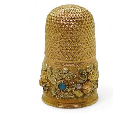 A DECORATIVE THIMBLE made in bright yellow metal, with applied three colour gold flowers and leaves, and set with three turqu