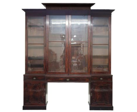 A LARGE 19TH CENTURY MAHOGANY BREAKFRONT LIBRARY BOOKCASE&nbsp; with stepped moulded cornices over pair of glazed doors flank