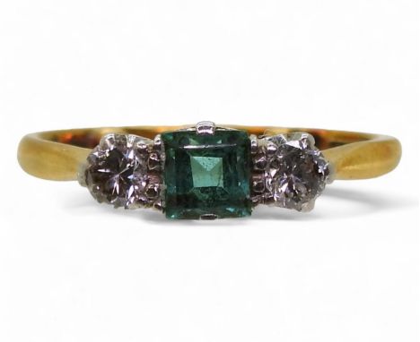 AN EMERALD & DIAMOND RING the classic 18ct gold three stone is set with two diamonds with an estimated approx diamond total o