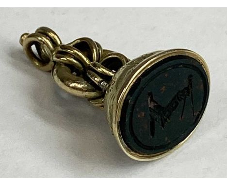 VICTORIAN GOLD SEAL FOB, the hardstone inset carved with arm holding a calliper type compass, machine tested as 10ct, 2.75cms