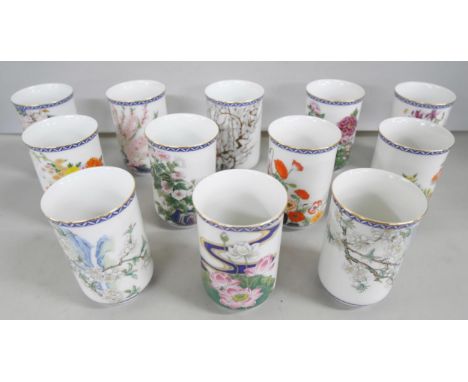A collection of twelve 1980s Japanese Franklin Mint porcelain sake cups with various floral motifs, in display case **PLEASE 