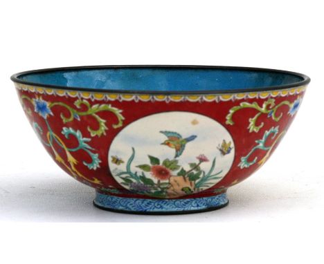 A Chinese enamel bowl decorated with birds, flowers and butterflies within roundels, on a red ground, four-character blue sea