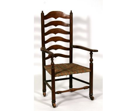 An early 19th century ladder back chair with rush seat and china casters.