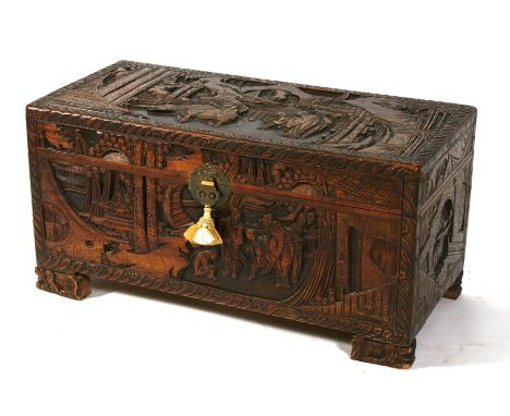 A Chinese camphorwood trunk heavily carved with figural scenes, 92cms (36ins) wide.