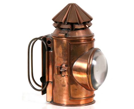 A late 19th / early 20th century copper hand held Police lamp with hooded bulls eye lens, the top vent revolving to operate o