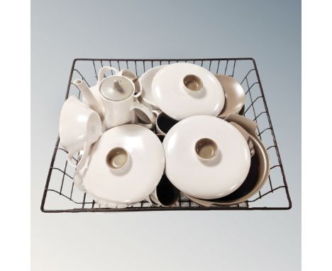A basket containing a quantity of vintage Poole tea and dinnerware. 