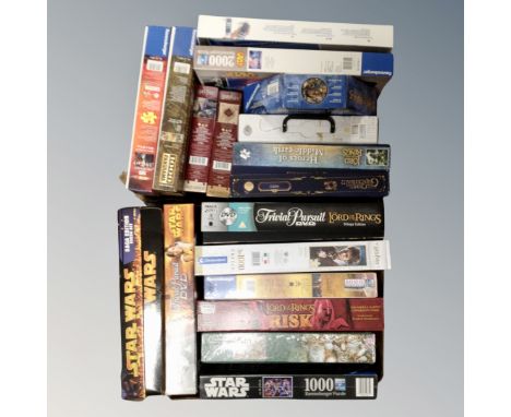 Two boxes containing a large quantity of jigsaws and board games relating to Harry Potter, Star Wars and Lord of the Rings. 