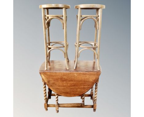 An oak gate leg table and a pair of Bentwood bar stools 